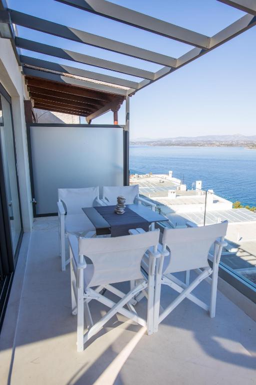 a table and chairs on a balcony with the ocean at Raise Spetses Sea View Villa in Spetses