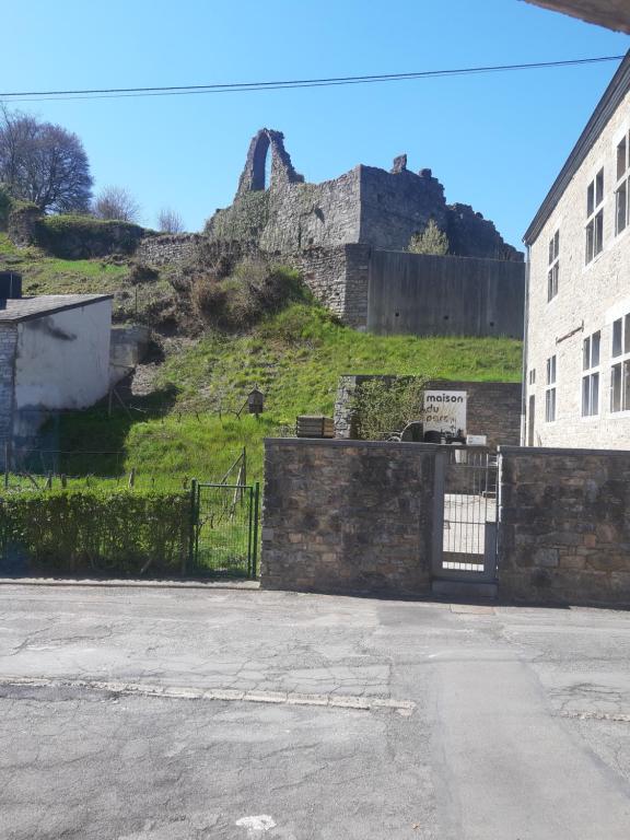 un bâtiment avec une porte en face d'un château dans l'établissement Gîte Le pt'i Baillis, à Nismes