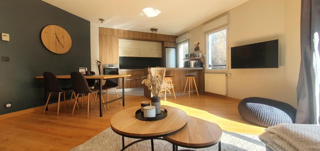 a living room with a table and a kitchen at La Perle du Semnoz in Annecy