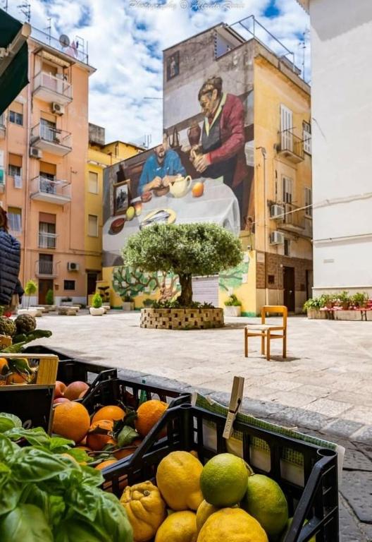 a bunch of fruit and vegetables in a basket in front of a mural at Casetta Sapienza in Gaeta