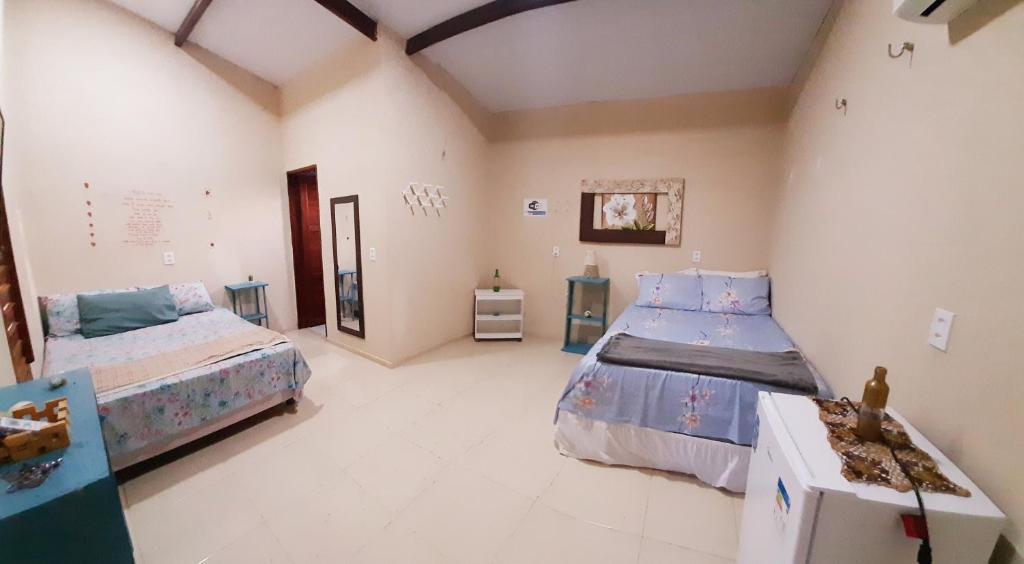 מיטה או מיטות בחדר ב-Vila Vintém Chalés
