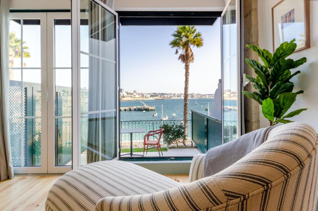 ein Wohnzimmer mit einem Sofa und Blick auf das Wasser in der Unterkunft Westlight Cascais Chalet - Adults Only in Cascais