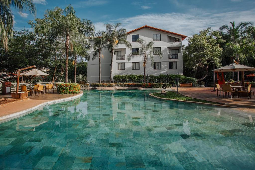 a swimming pool in front of a building at Rio Quente Resorts - Hotel Luupi in Rio Quente