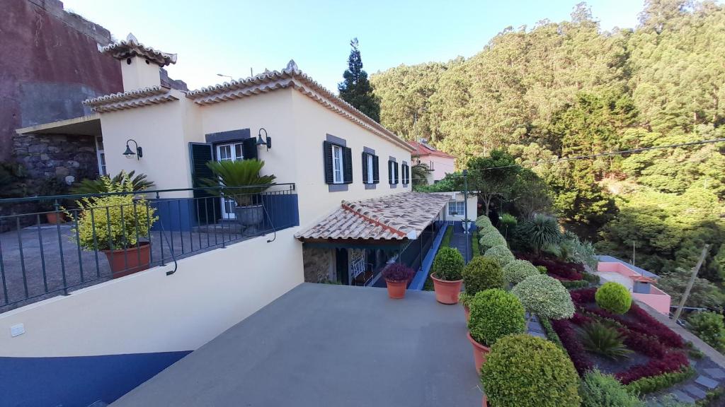 ein Haus mit einem Balkon mit Pflanzen darauf in der Unterkunft Quintinha da Romana in Câmara de Lobos