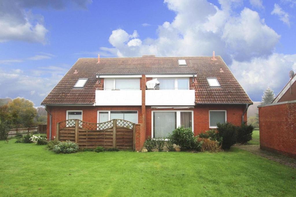 a red brick house with a green yard at Apartment, Garding in Garding