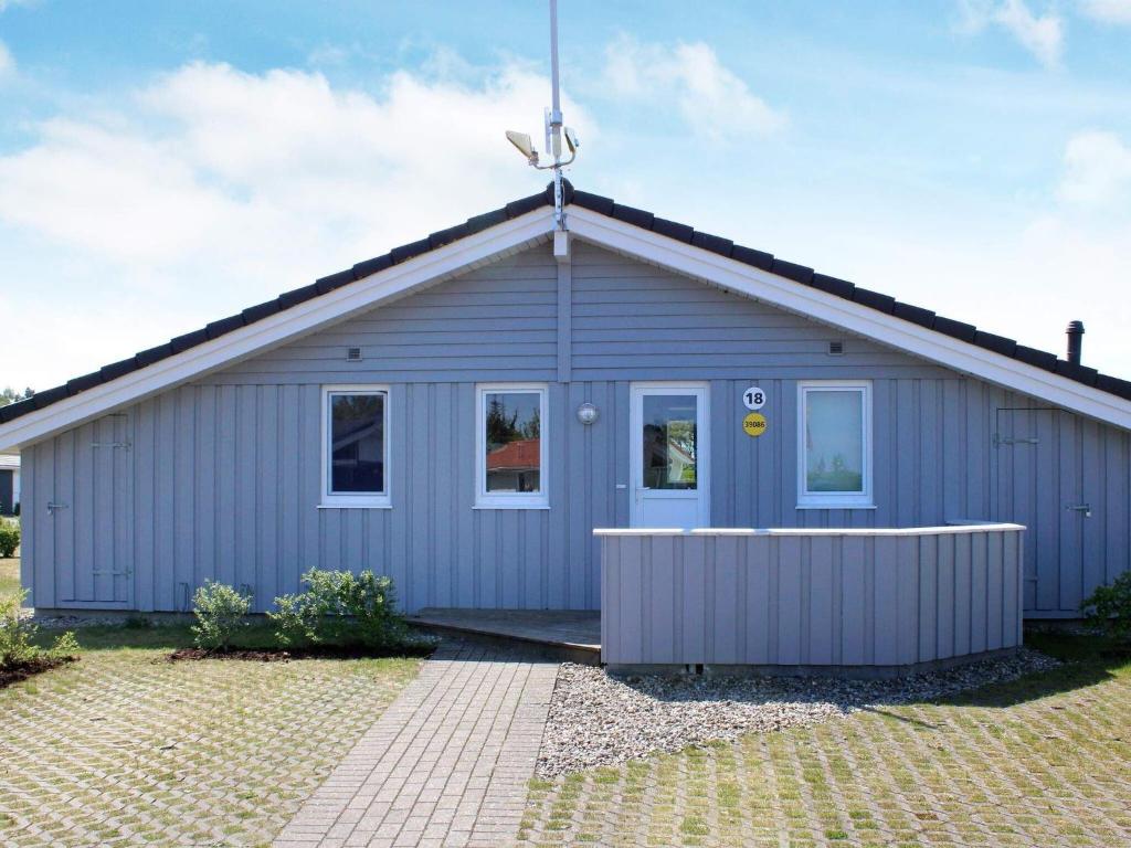 a small blue house with at Three-Bedroom Holiday home in Grömitz 19 in Grömitz