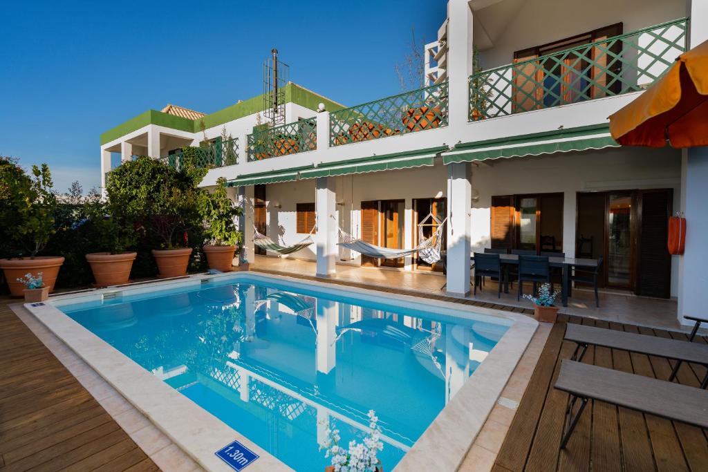 Holiday villa in elite residential area of Faro في فارو: منزل أمامه مسبح