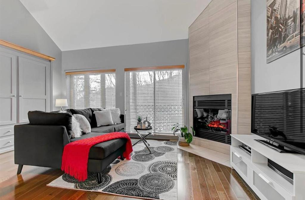 a living room with a couch and a fireplace at Condo Ski-In Ski-Out Stoneham in Stoneham
