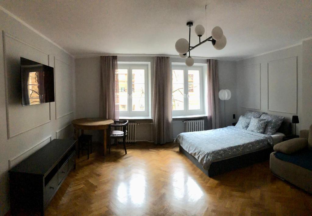 sypialnia z łóżkiem, biurkiem i stołem w obiekcie Apartament Central Nº1 we Wrocławiu