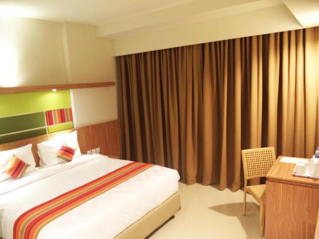 a hotel room with a bed and a desk at Kyriad Hotel Airport Jakarta in Tangerang