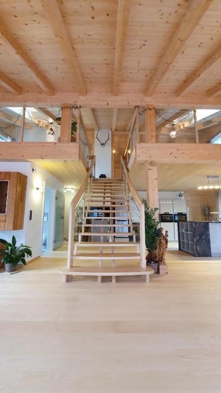 eine Treppe in einem großen Gebäude mit Holzdecken in der Unterkunft Ferienwohnung Anna Salzburg Grödig in Grödig