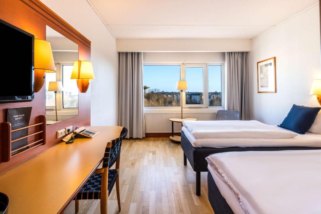 奧胡斯的住宿－西奧胡斯斯堪迪克酒店，酒店客房配有两张床和一张书桌