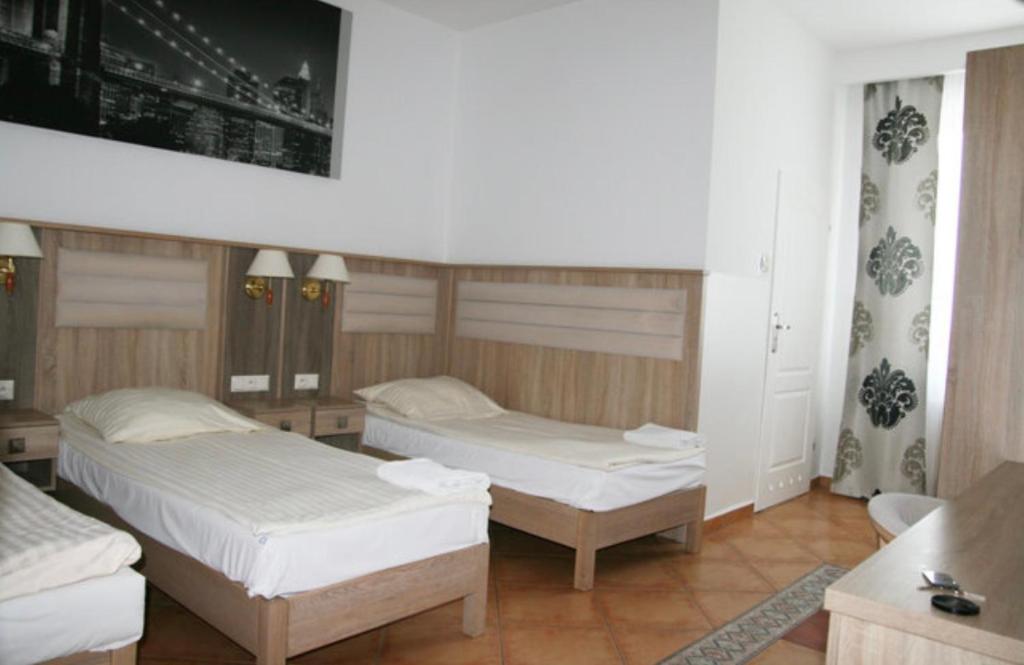 um quarto com 2 camas e uma televisão em Lotos em Rawicz