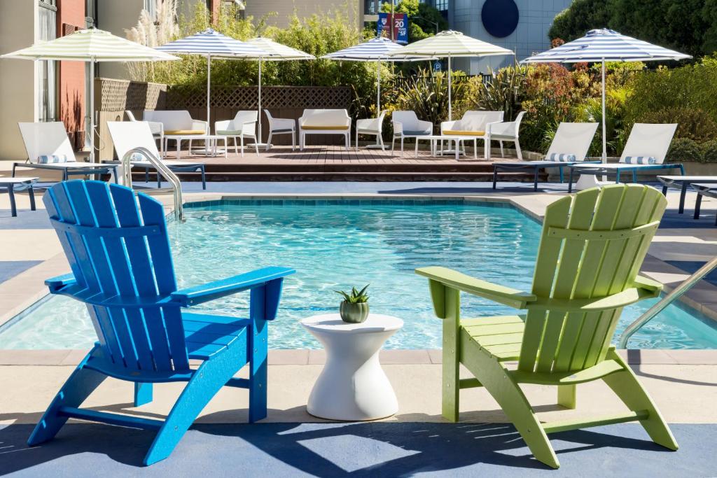 two blue and green chairs next to a swimming pool at Hotel Caza Fisherman's Wharf in San Francisco
