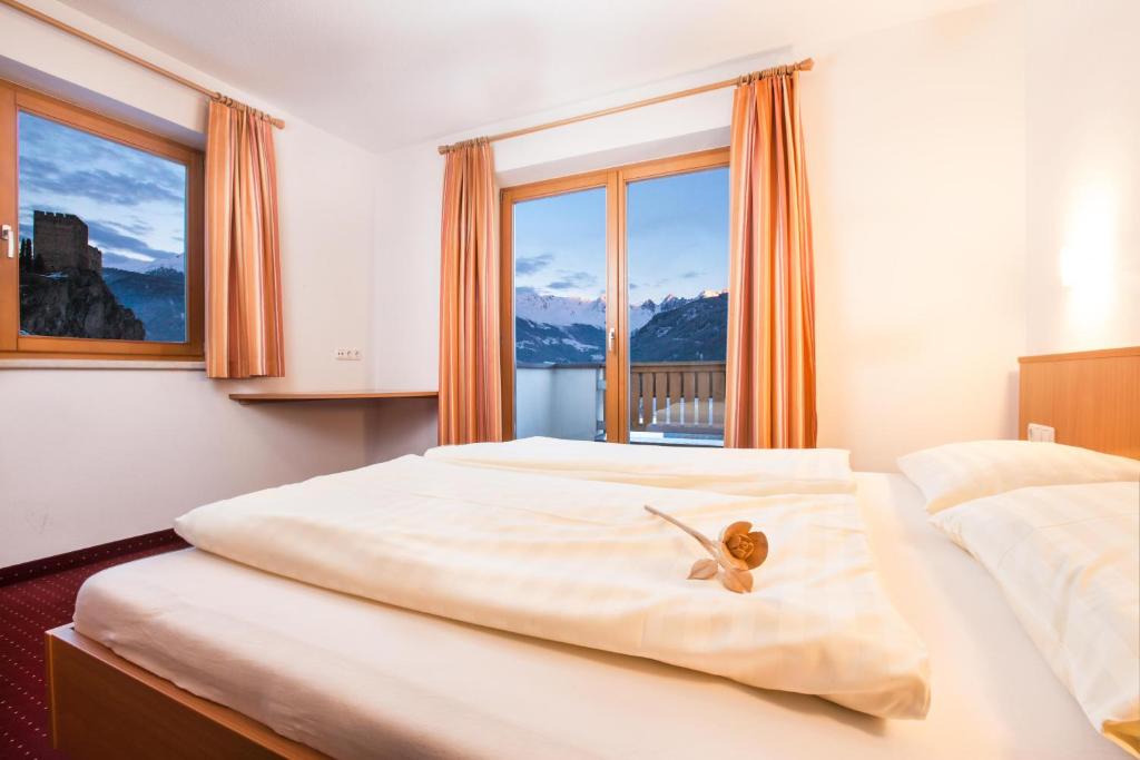a bedroom with two beds and a large window at Apart Hotel Neier in Ladis