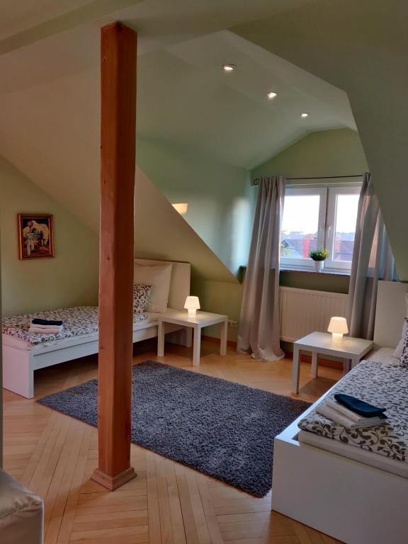 a attic room with two beds and a window at The Lovely Garden House in Zagreb