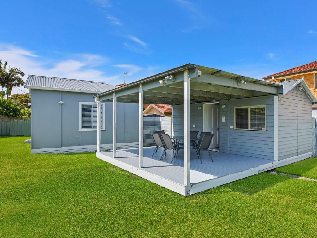 una terraza cubierta con 2 sillas en una casa en Pacific Family Retreat, en Long Jetty