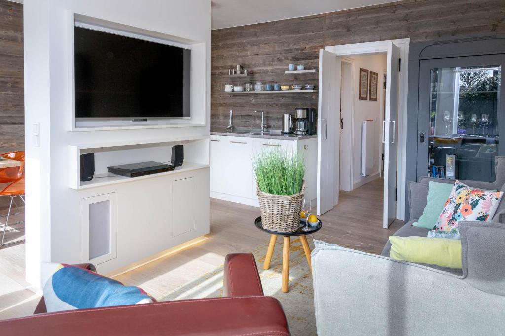 ein Wohnzimmer mit einem Flachbild-TV an der Wand in der Unterkunft Sylter Meerholz in Tinnum