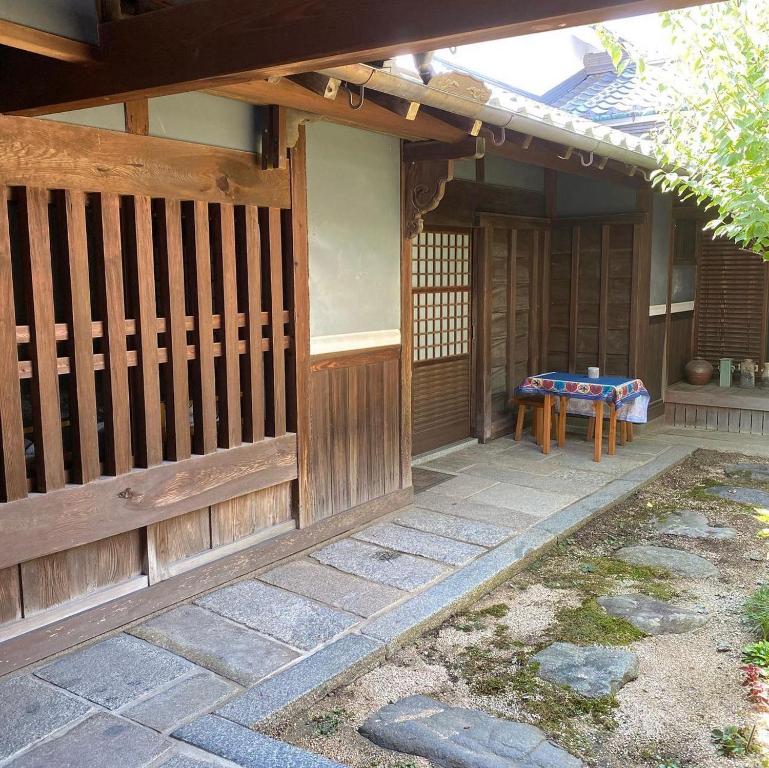 una casa con una valla de madera y una mesa en 古民家民泊かえるて, en Kashihara