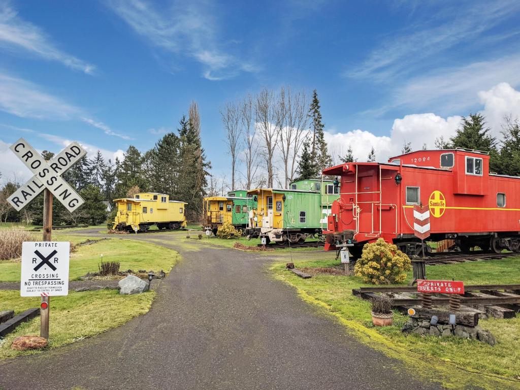 a train yard with train cars and a railroad crossing at Olympic Railway Inn in Sequim