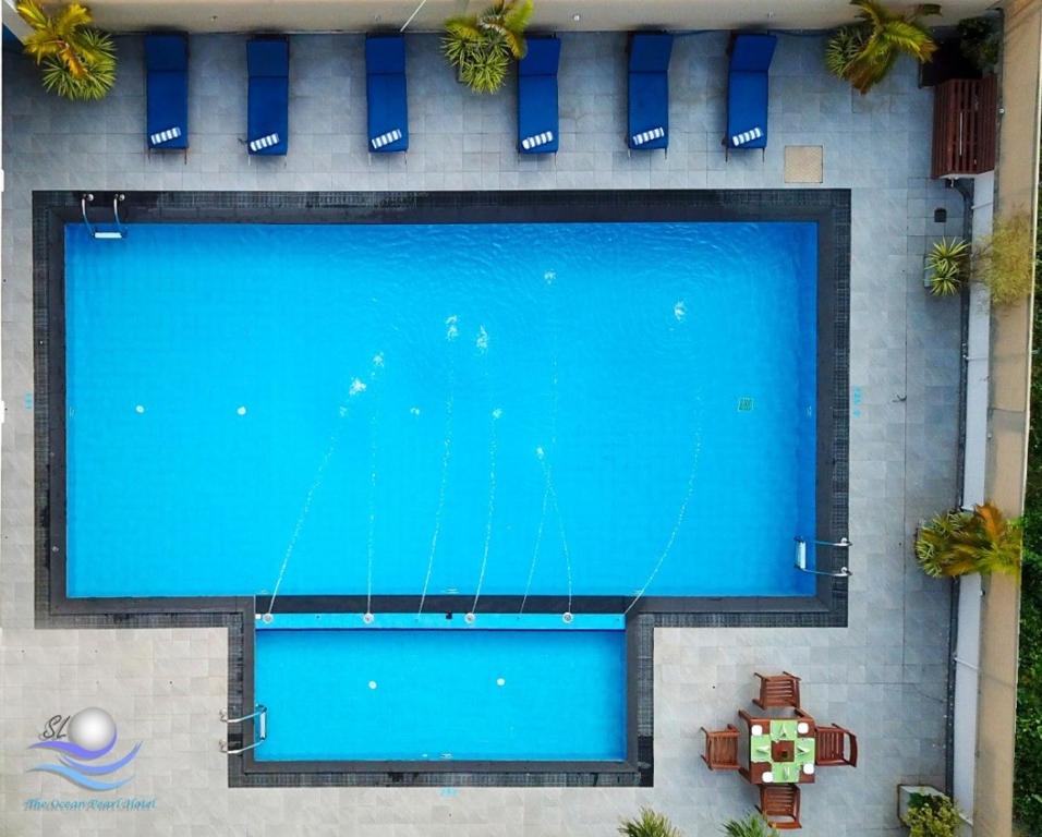 an overhead view of a large blue swimming pool at The Ocean Pearl Hotel Negombo in Negombo