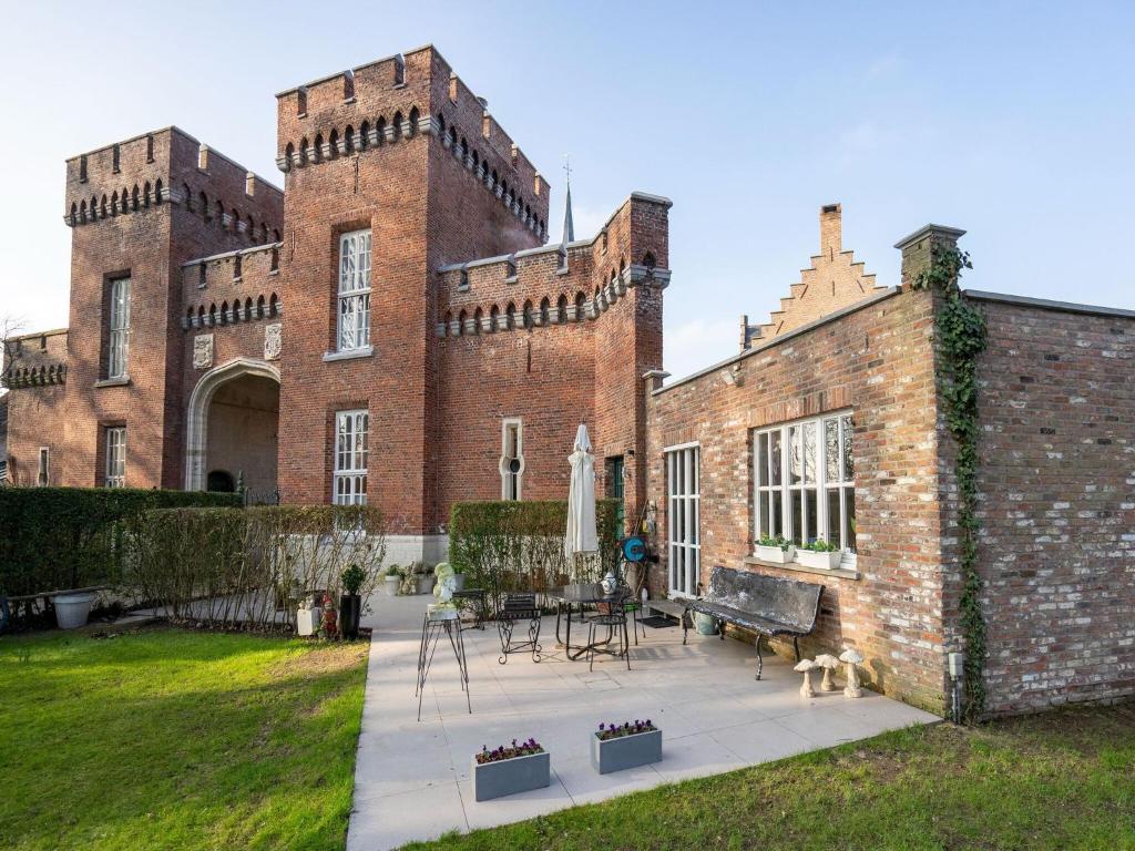 a large brick building with a patio in front of it at Apartment in Kruibeke at Wissekerke Castle in Kruibeke