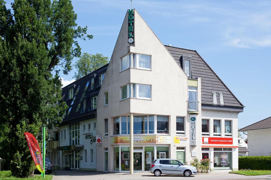 a building with a car parked in front of it at Hotel Jahnke in Neubrandenburg