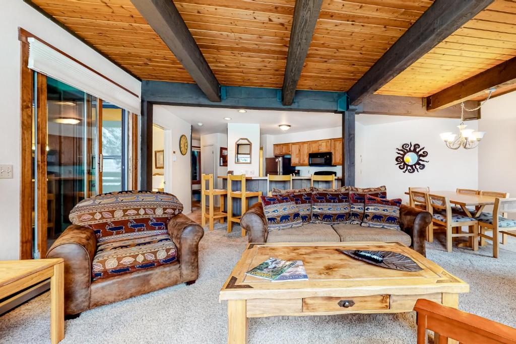 a living room with leather furniture and a wooden ceiling at Lodge at Steamboat F103 in Steamboat Springs