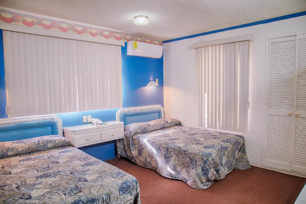 a blue room with two beds and a sink at HSE Economy in Ciudad Madero