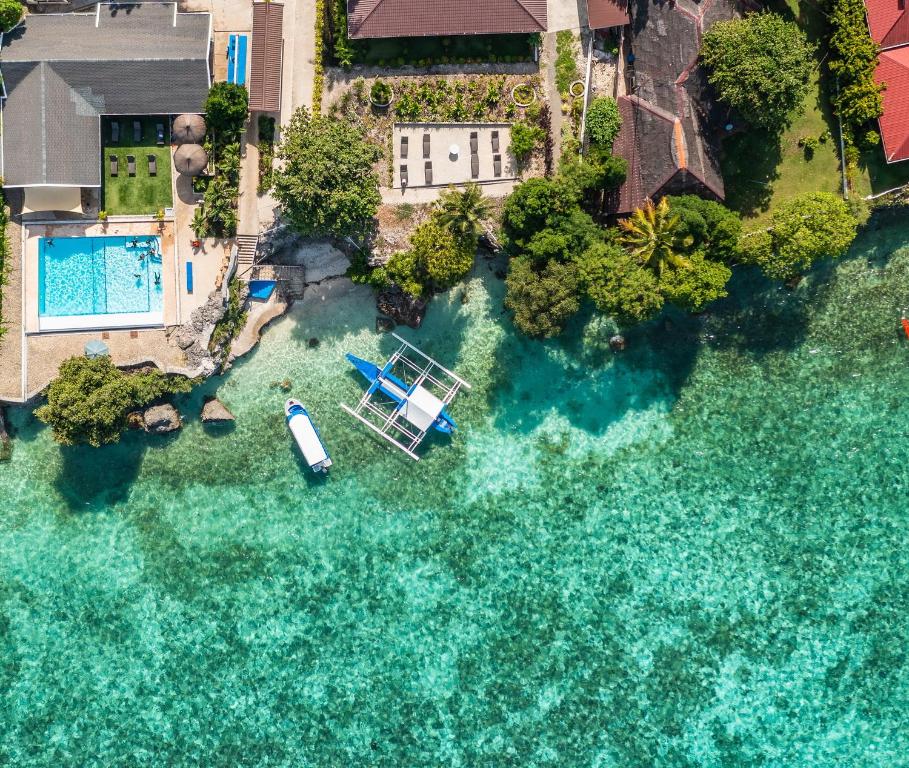 - une vue aérienne sur une piscine avec un bateau dans l'eau dans l'établissement Cebu Seaview Dive Resort, à Moalboal