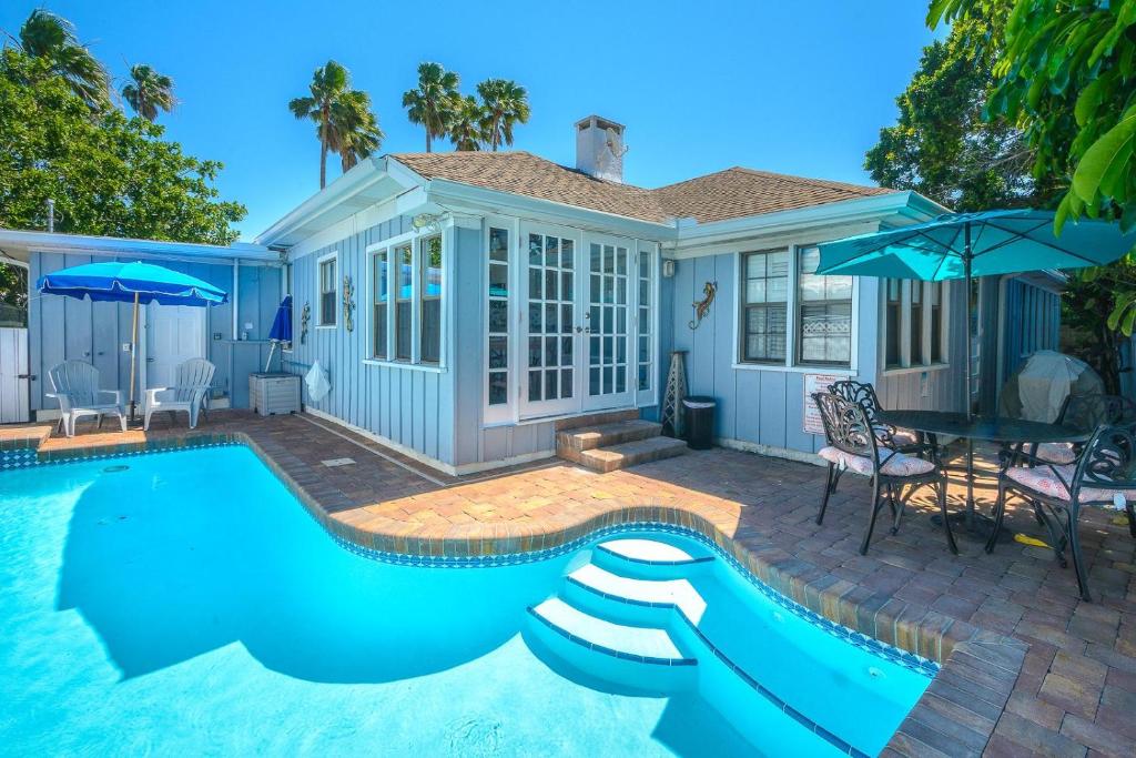 a pool with a slide in front of a house at Coconut Beach House in Clearwater Beach