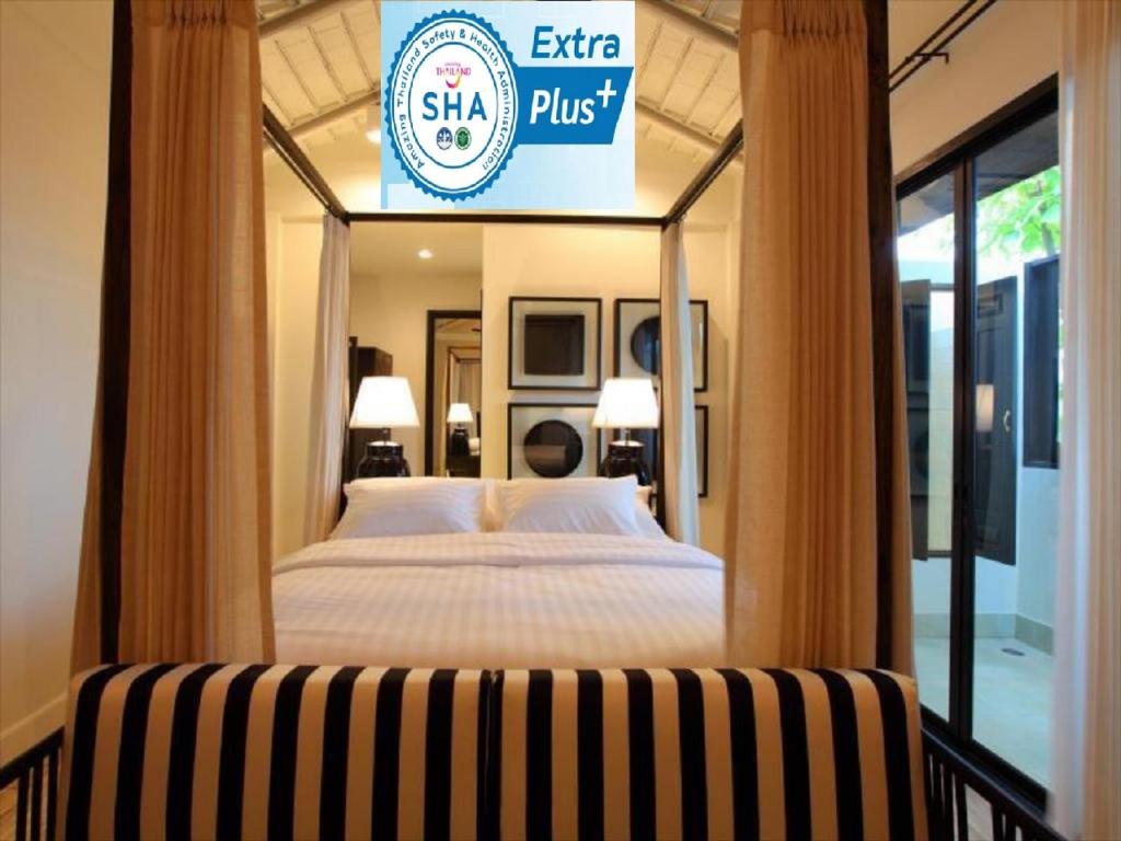 a bedroom with a bed and a sign that reads shahi plus at 99 The Gallery Hotel- SHA Extra Plus in Chiang Mai