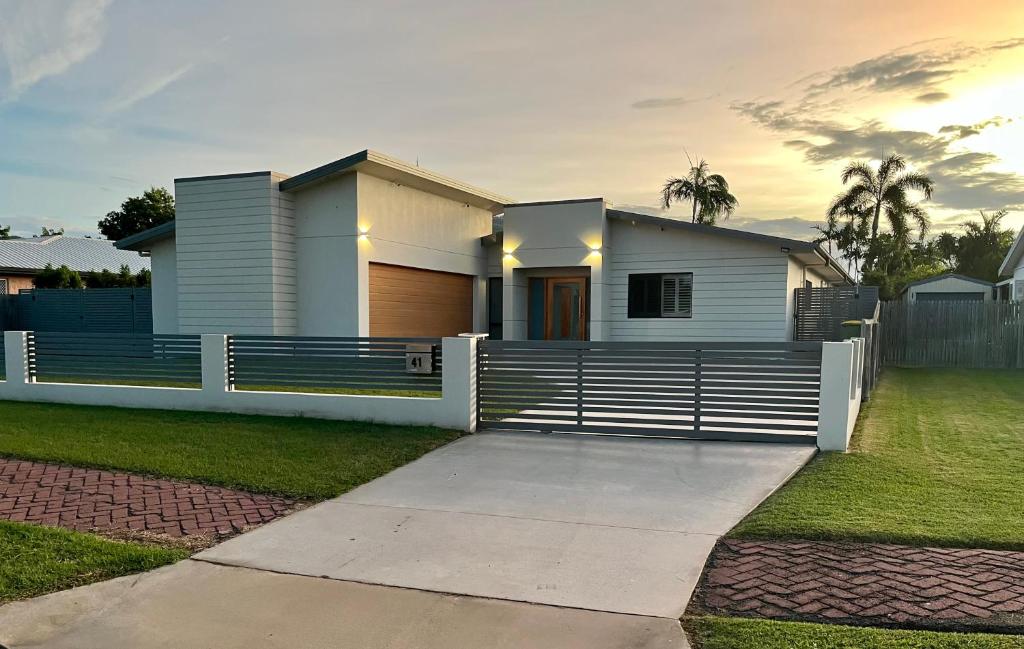 Biały dom z płotem i podjazdem w obiekcie Luxury home with huge pool and putting green! w mieście Townsville