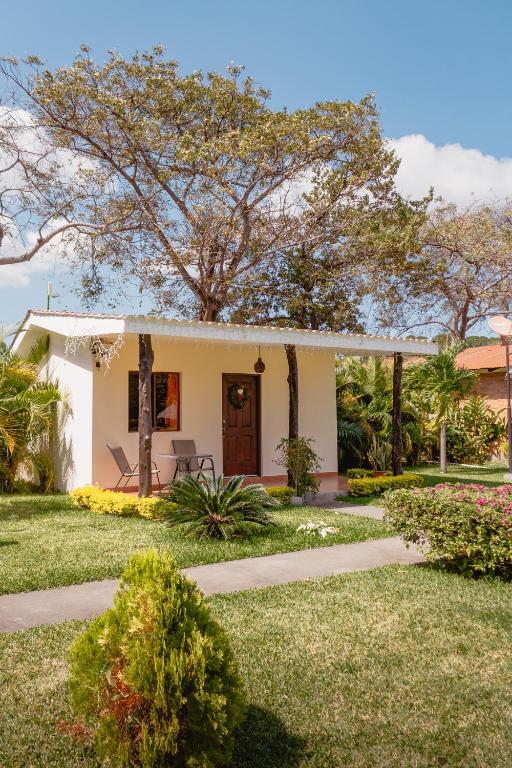 una pequeña casa blanca con un árbol en el patio en Hotel Boutique Victoria, en Moyogalpa