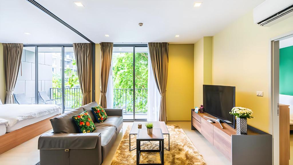 - un salon avec un canapé et une télévision dans l'établissement Hill & Valley Khaoyai by Nancy, à Ban Huai Sok Noi