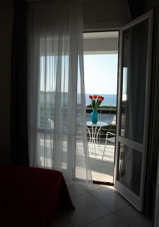 a room with a sliding glass door with a vase of flowers at Brezza Di Grecale in Trapani