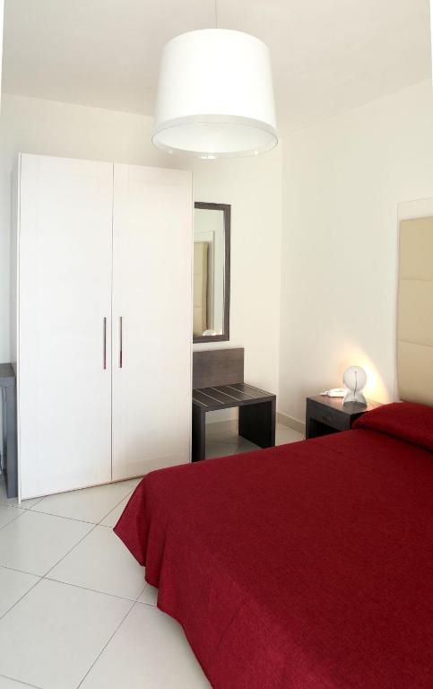 a bedroom with a red bed and white cabinets at Brezza Di Grecale in Trapani