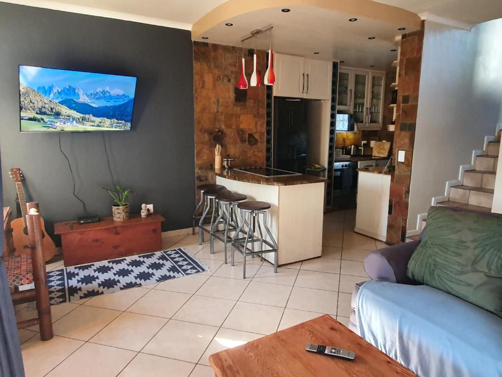 a living room with a couch and a kitchen at Hacienda Palms in Richards Bay