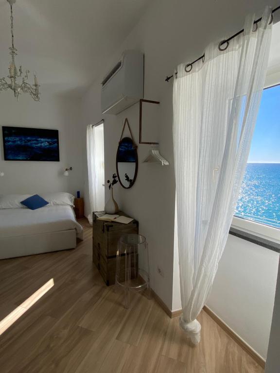 a bedroom with a bed and a window with the ocean at La Bloo di Vernazza - Sea View - AC&WiFi - Vernazzarentals in Vernazza