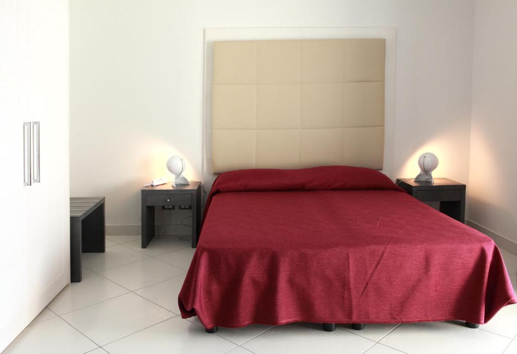 a bedroom with a red bed with two night stands at Brezza Di Grecale in Trapani