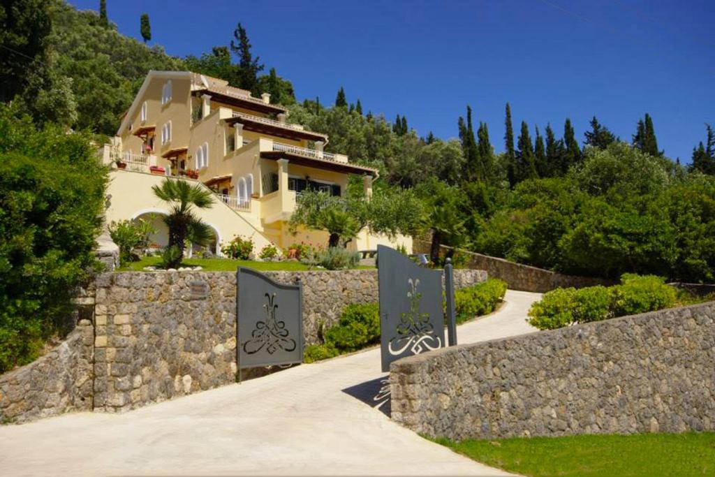 dom na wzgórzu z kamienną ścianą w obiekcie Natalia Apartment B with panoramic sea views of Agios Gordios bay w mieście Agios Gordios