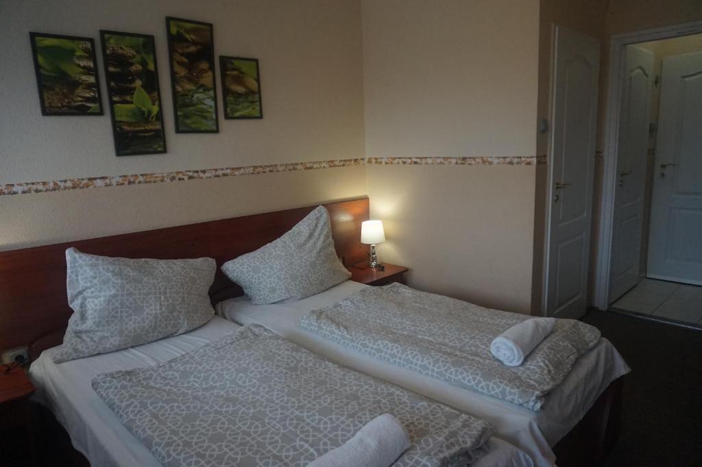 Łóżko lub łóżka w pokoju w obiekcie Hotel Ajka Üzletház Panzió Ajka