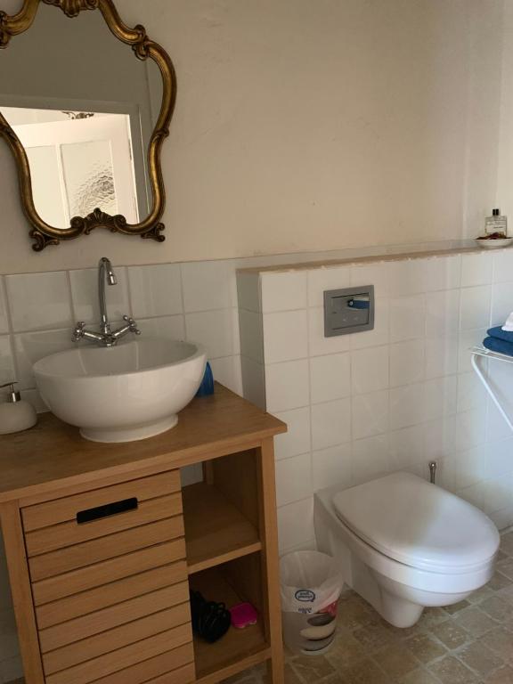 uma casa de banho com um lavatório, um WC e um espelho. em La Clé de la Porte B&B em Antibes