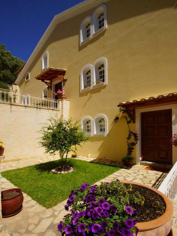 A garden outside Natalia Apartment A with panoramic sea views of Agios Gordios bay