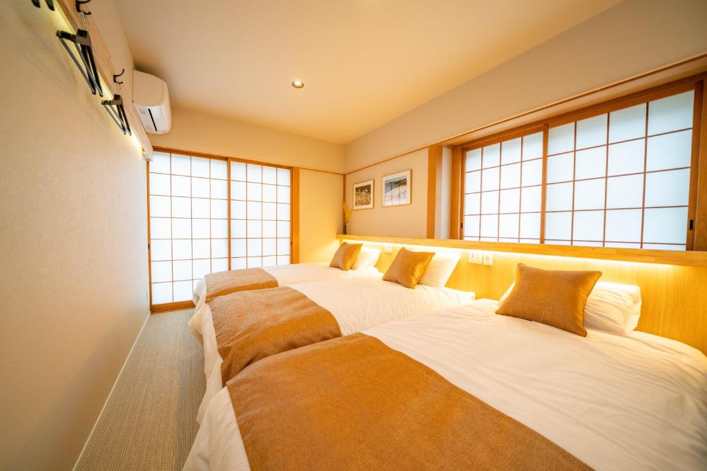 three beds in a room with windows at Pets OK! Hakone Life resort Toki sengokuhara in Hakone