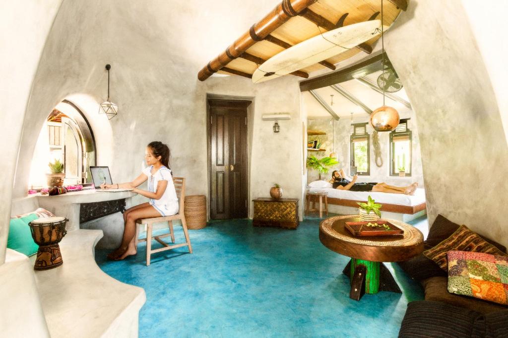 a woman sitting at a desk in a room at Dome Lombok in Bumbang