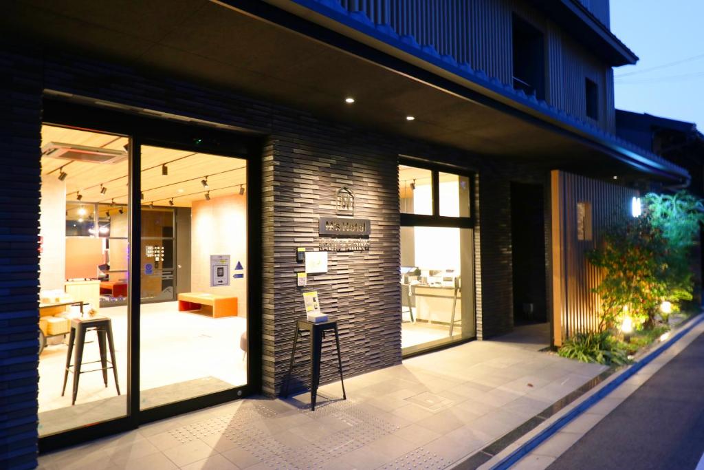 a building with glass doors and a stool on a patio at M's Hotel Sanjo Omiya in Kyoto