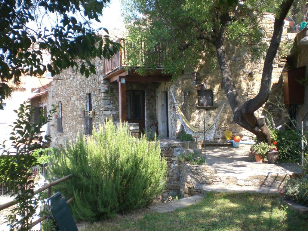 una vieja casa de piedra con un árbol en el patio en Il Mandorlo, en Montecorice