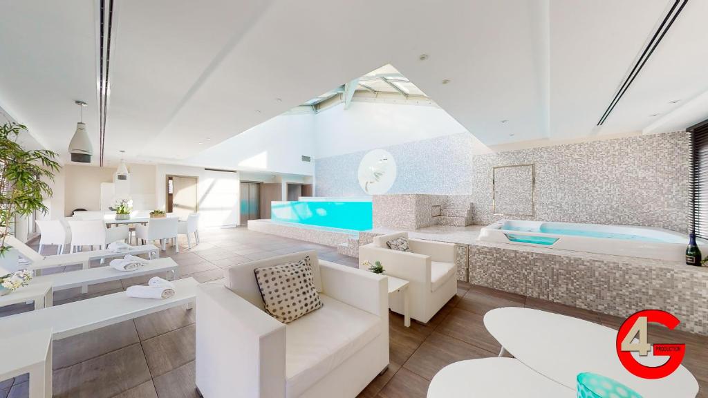 a living room with white furniture and a tub at THE POOL HOUSE Cannes in Cannes