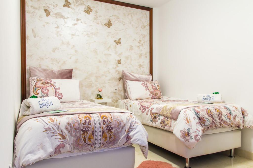 Un dormitorio con dos camas y un espejo. en Villa Garoed, en Playa Blanca
